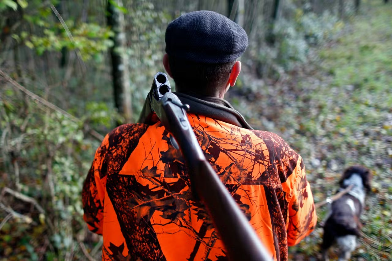 Chasseur installant un appareil mécanique LV Migration au lever du jour